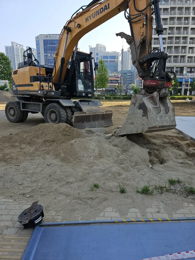 굴착기 버킷으로 잡석을 고르며 바닥을 정리하는 모습