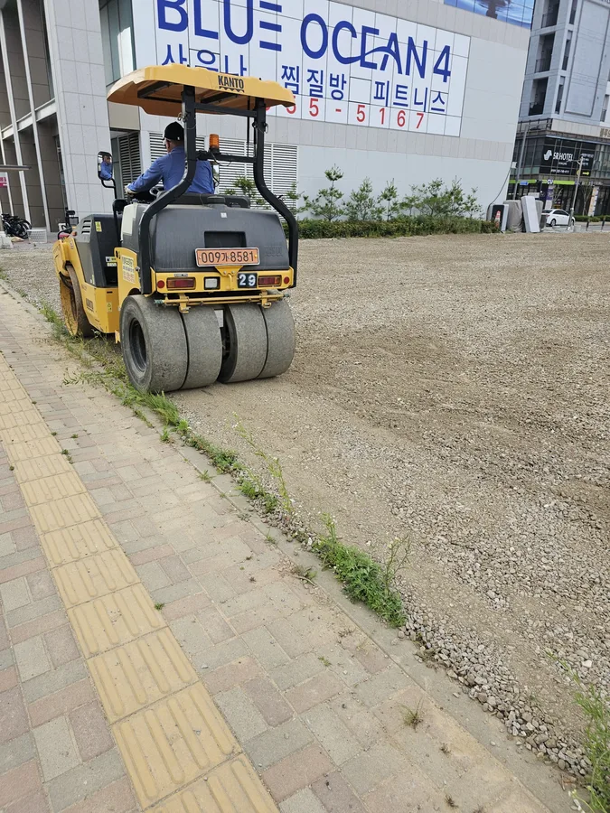 진동 롤러로 잡석 바닥을 다지는 2일차 작업 모습